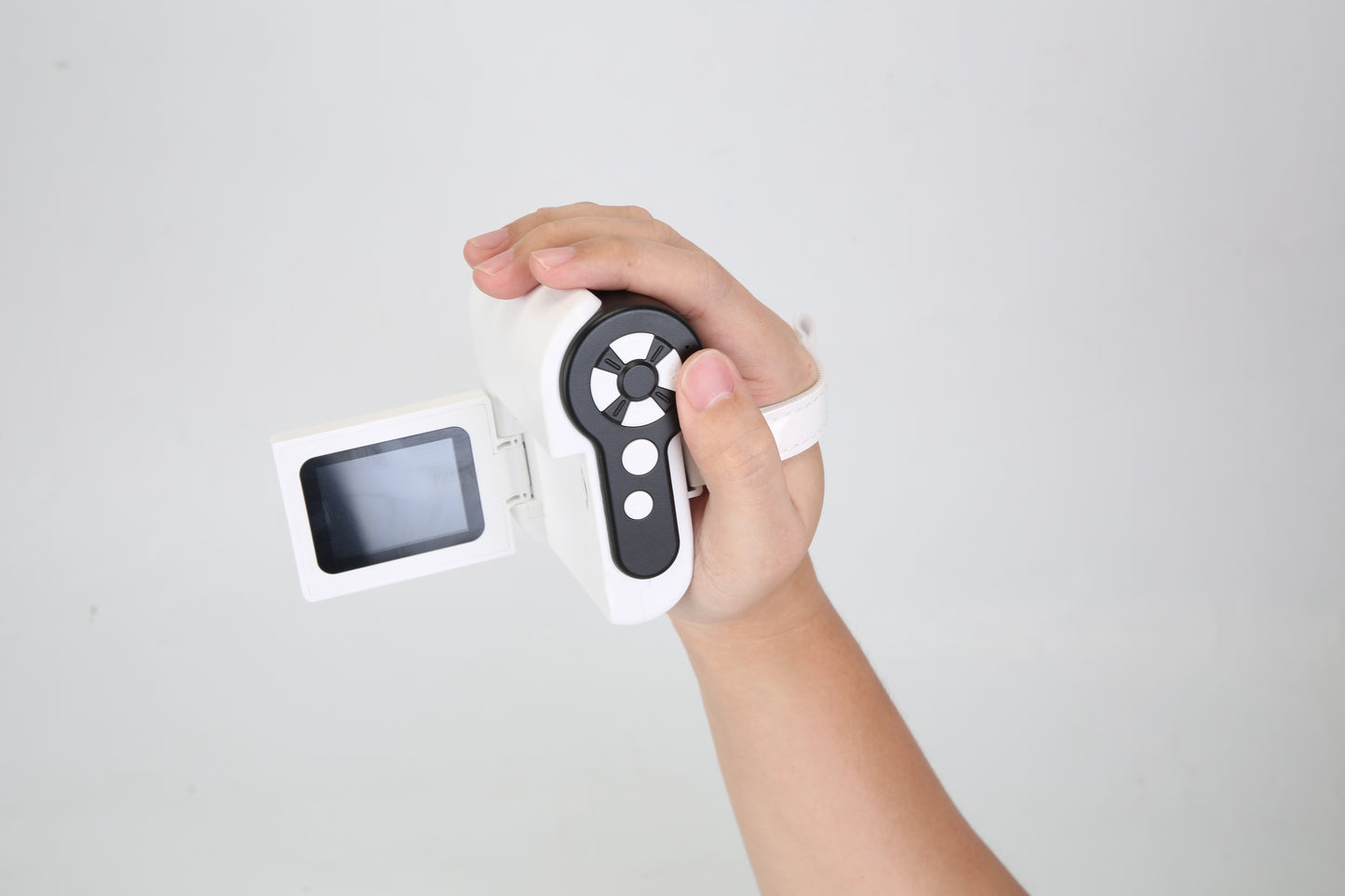 Hand holding a digital thermometer against a light gray background