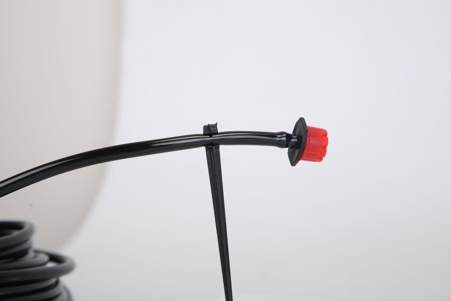 Black hose with a red cap on a white background