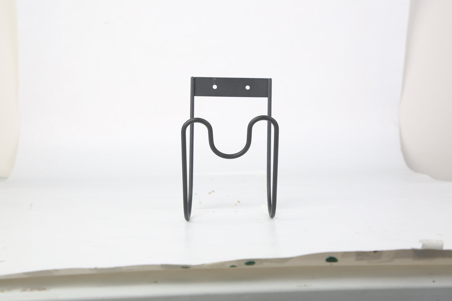 Metal bike holder attached to a white wall