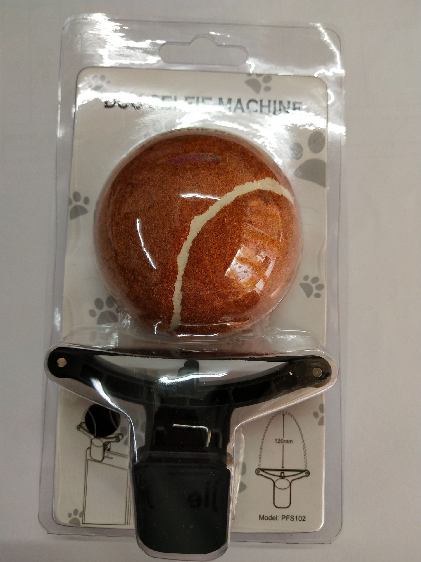 Dog toy with packaging featuring a ball and handle on a white background