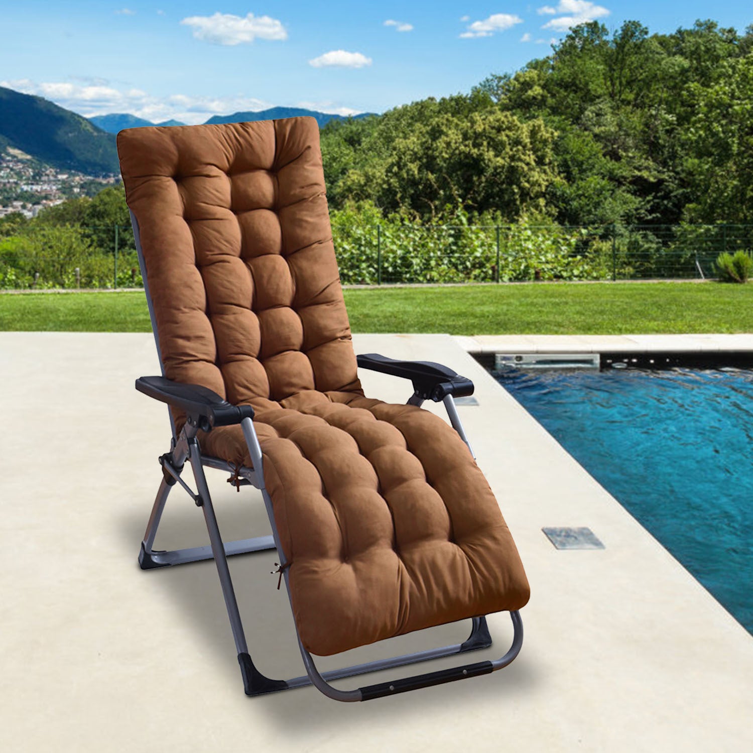Brown lounge chair with quilted cushions by a poolside with greenery and mountains in the background