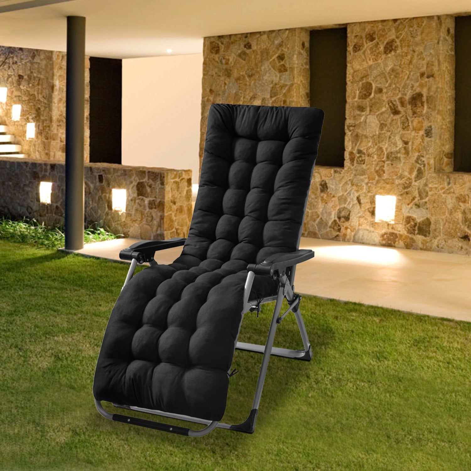 Black recliner chair on a grassy area with a stone building in the background