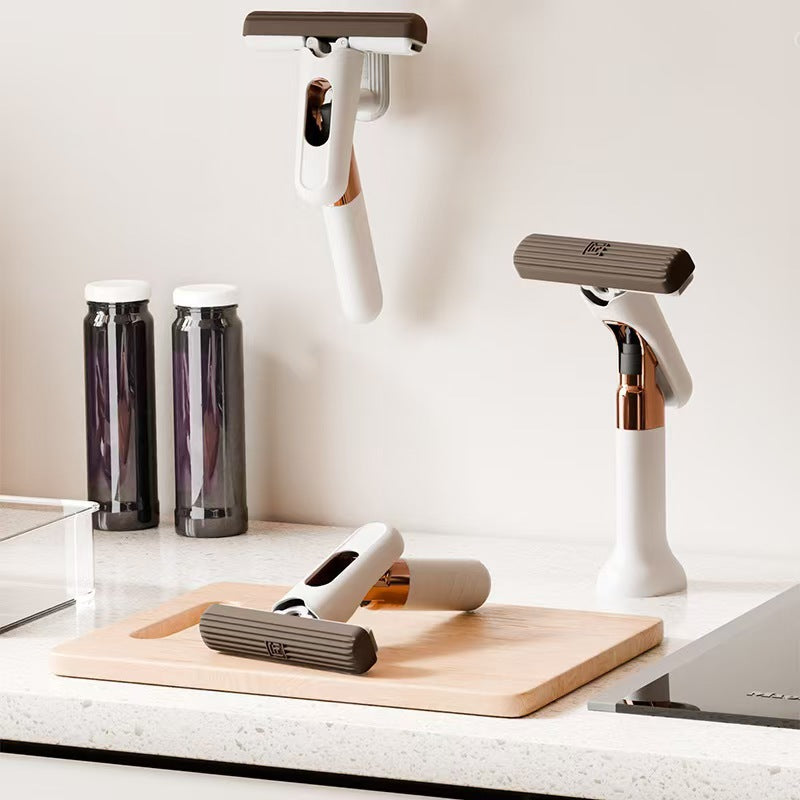 White handheld vacuum cleaner on a kitchen counter with cleaning tools.