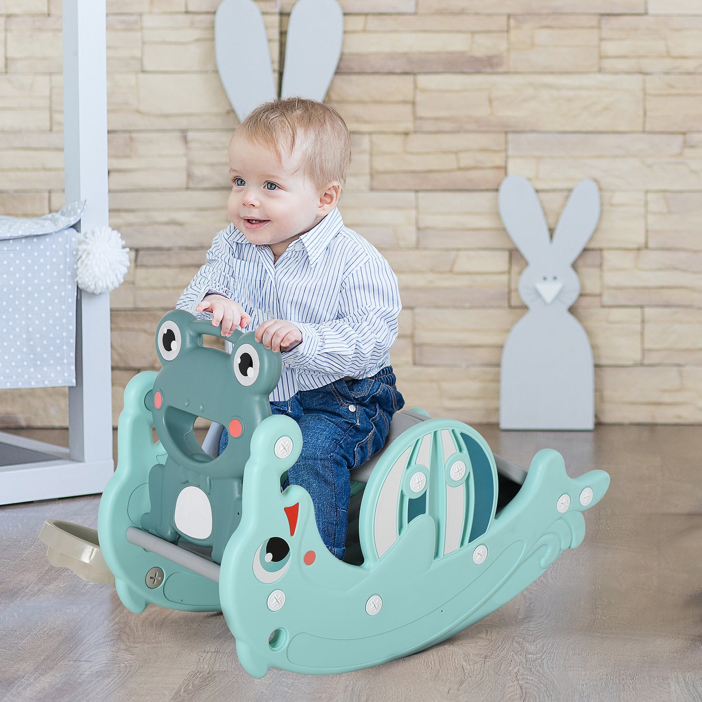 Child sitting on a green rocking toy with bunny ears in the background