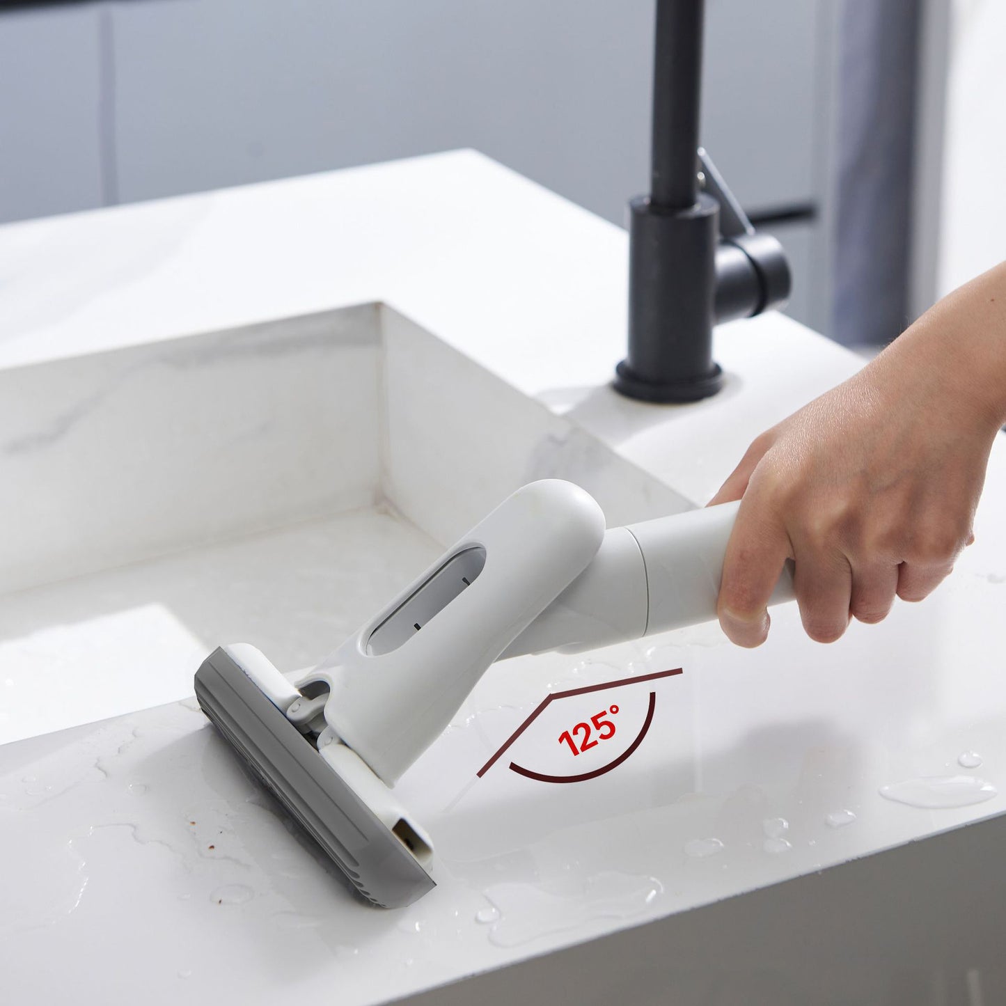 Hand using a white cleaning tool on a white surface with a red angle indicator.