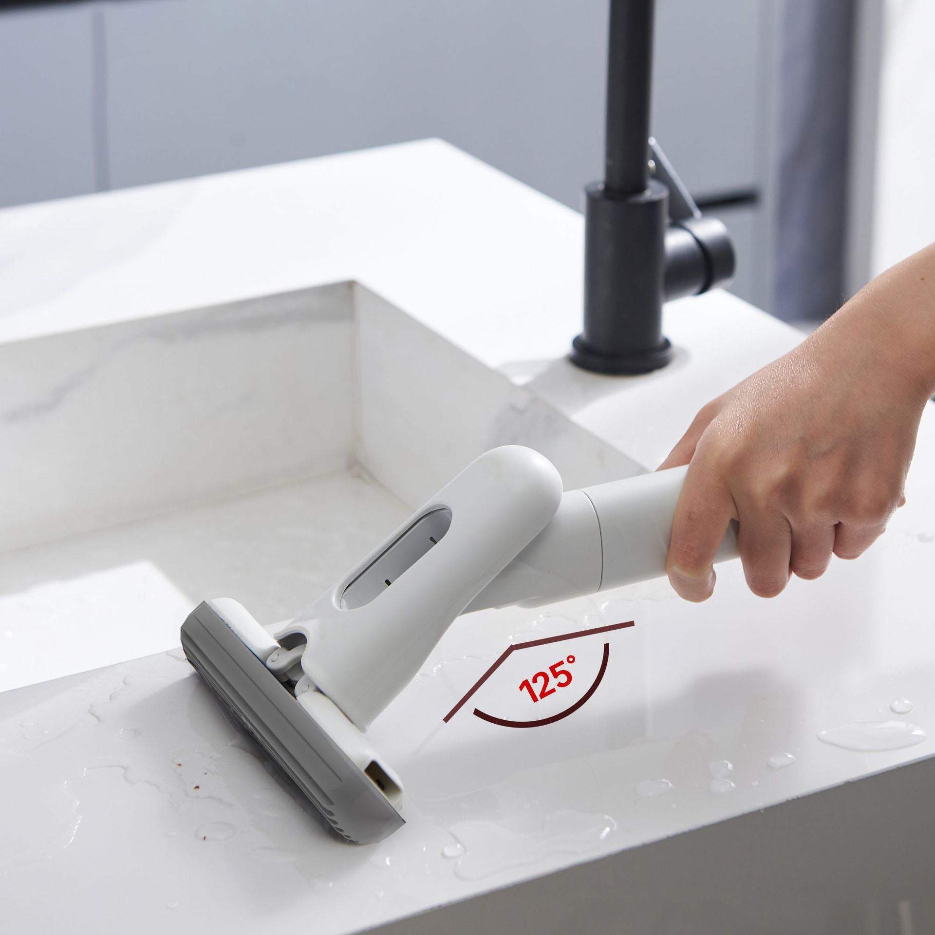 Hand using a white cleaning tool on a white surface with a red angle indicator.