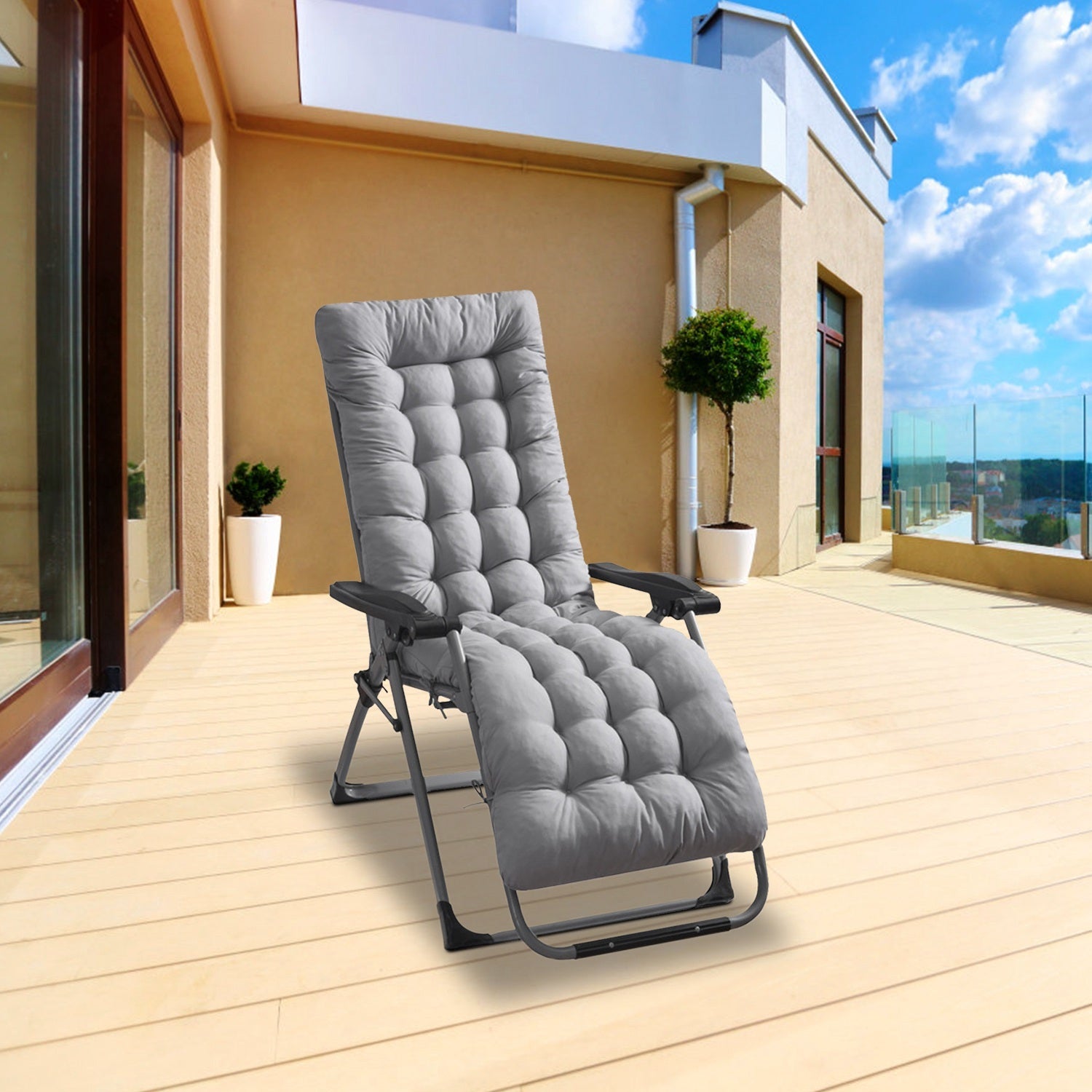 Gray lounge chair on a wooden deck with a modern building and blue sky in the background