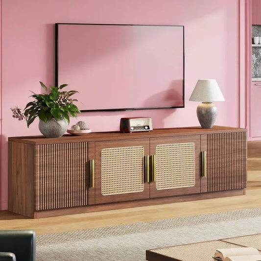 Wooden entertainment console with decorative items against a pink wall