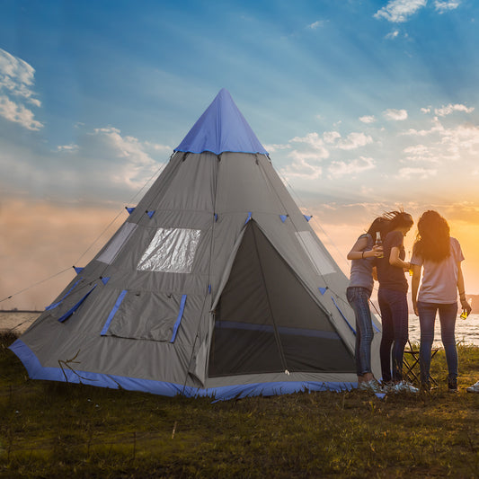 Two people standing next to a large gray and blue tent with a sunset in the background.